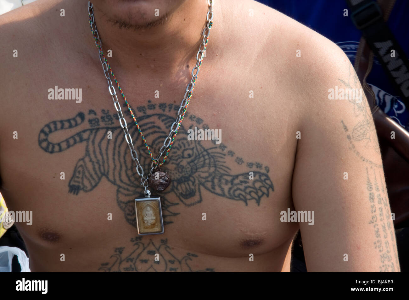 A young man`s tattooed chest at the Wat Bang Phra temple in Thailand, where monks tattoo their devotees with protective prayers. Stock Photo